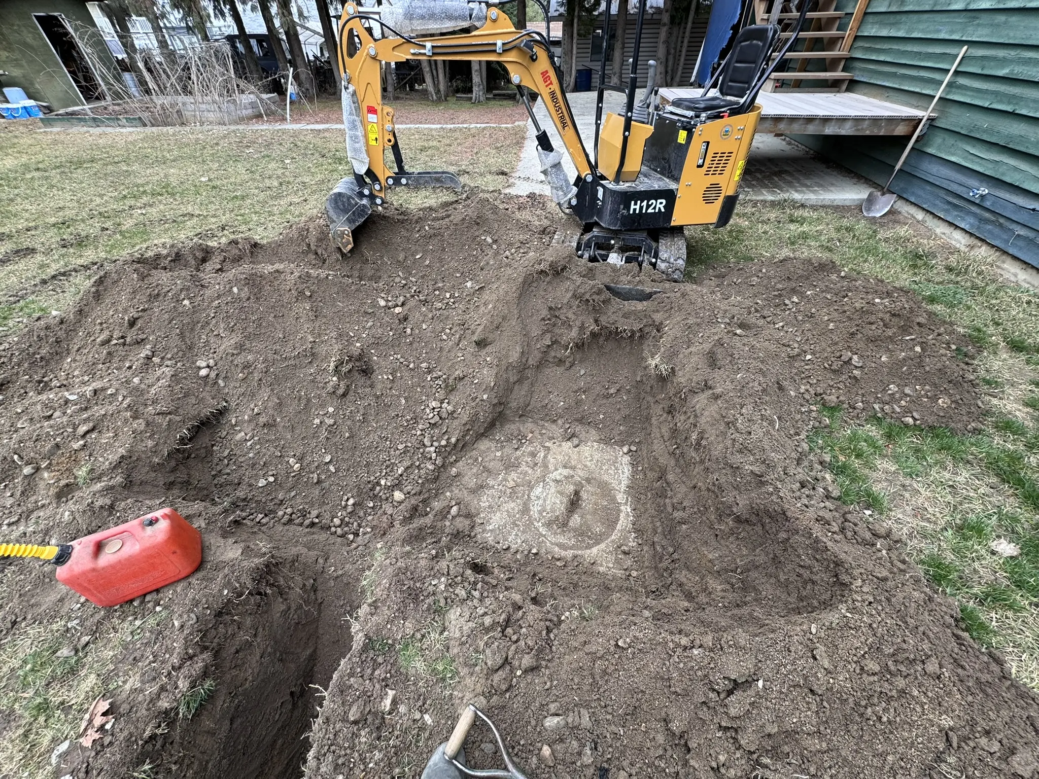 Mini excavator exposing a septic access point